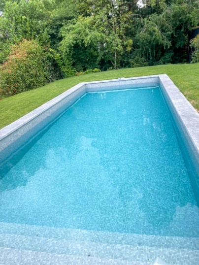Pose de mosaïques de verre Murano gris dans une piscine